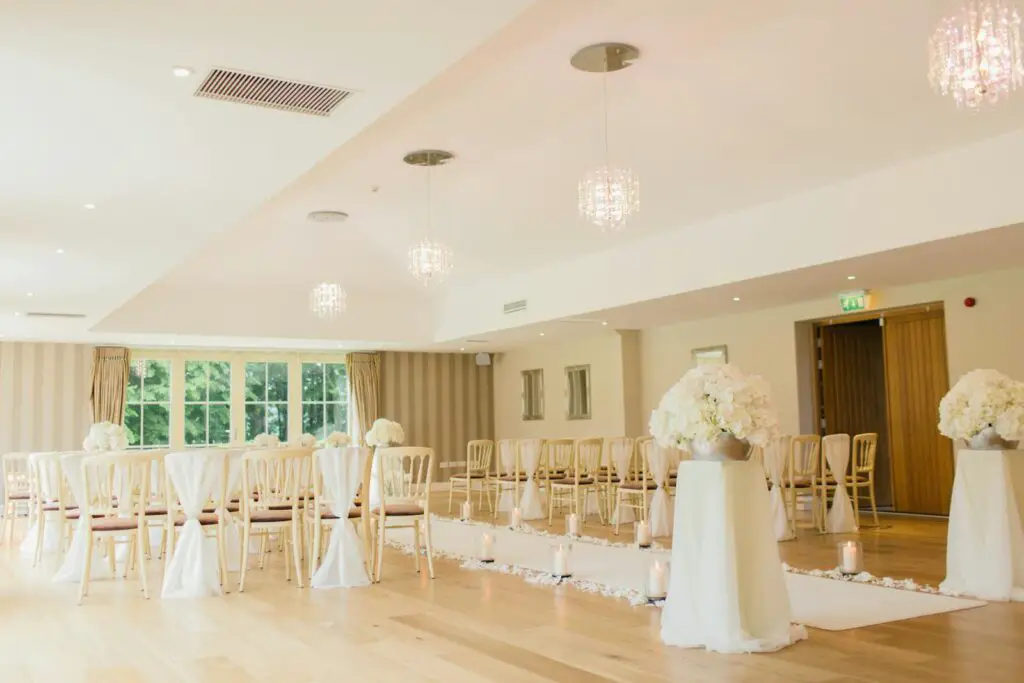 Brightly lit indoor wedding venue with elegant seating and floral decor, perfect for luxurious ceremonies.