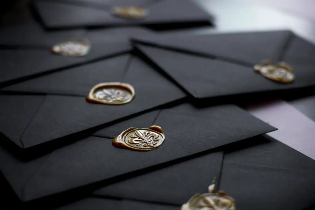 Best Places To Print Wedding Invitations 1 Close-up of stylish black envelopes featuring vintage wax seals, perfect for luxury invitations.
